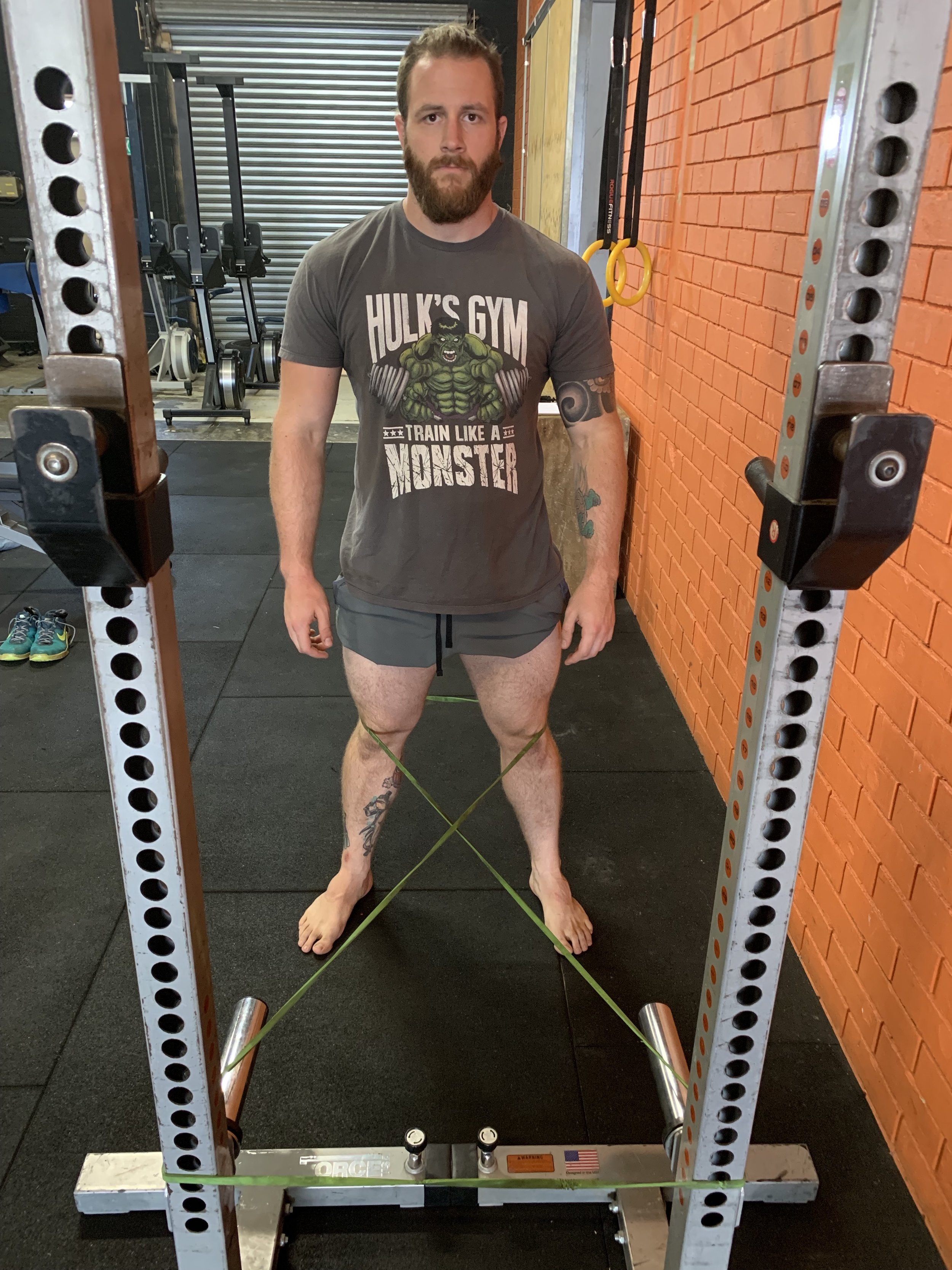 Set-up for using resistance bend to correct knee valgus while squatting.