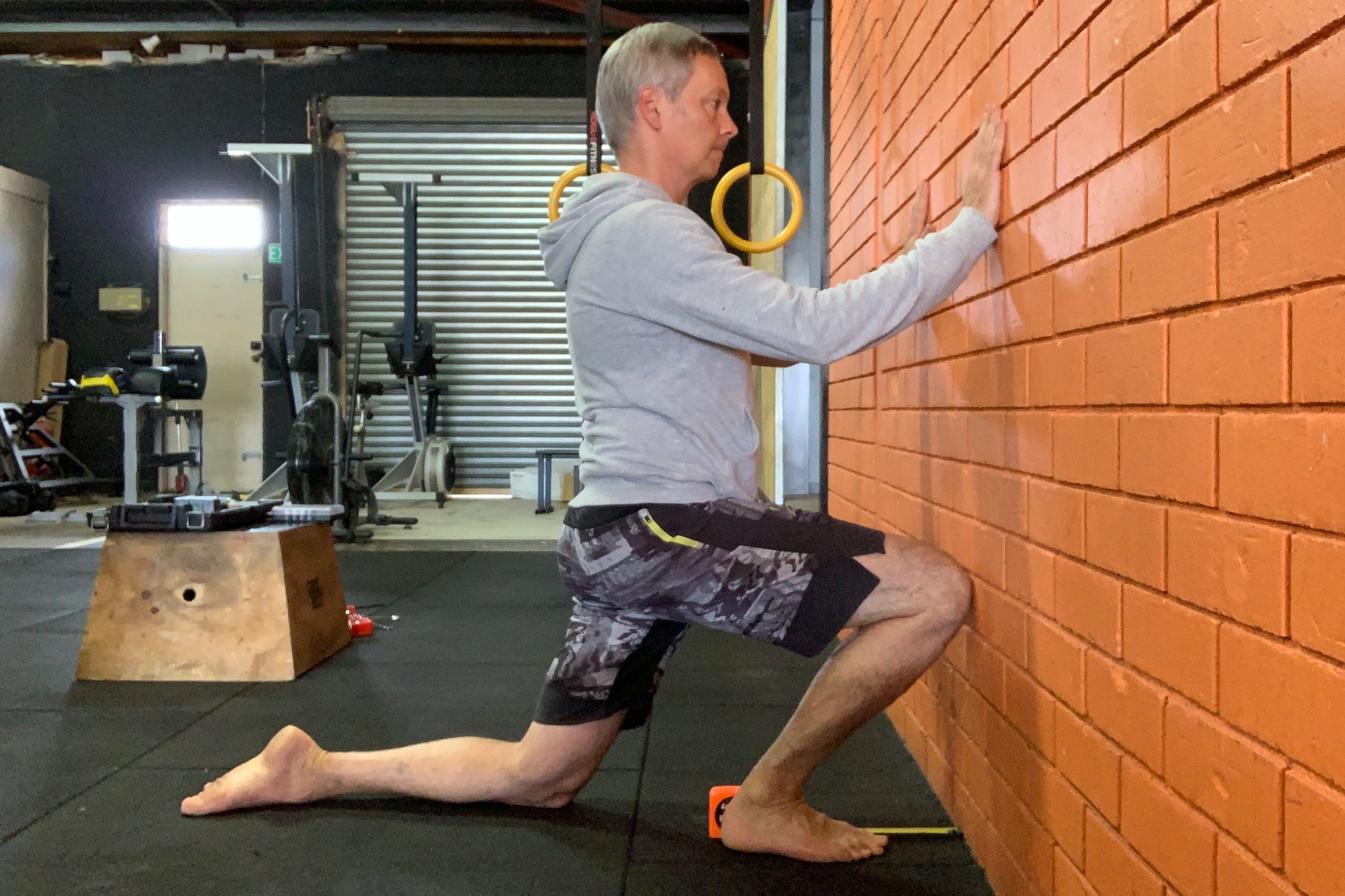 PASS: You can touch your knee to the wall without lifting your heel or letting your knee fall in